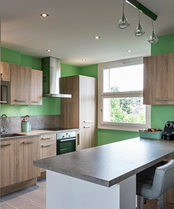 Cuisine contemporaine avec mur vert et meuble en bois