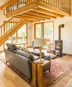 Salon d'une maison rénovée en bois avec poilon